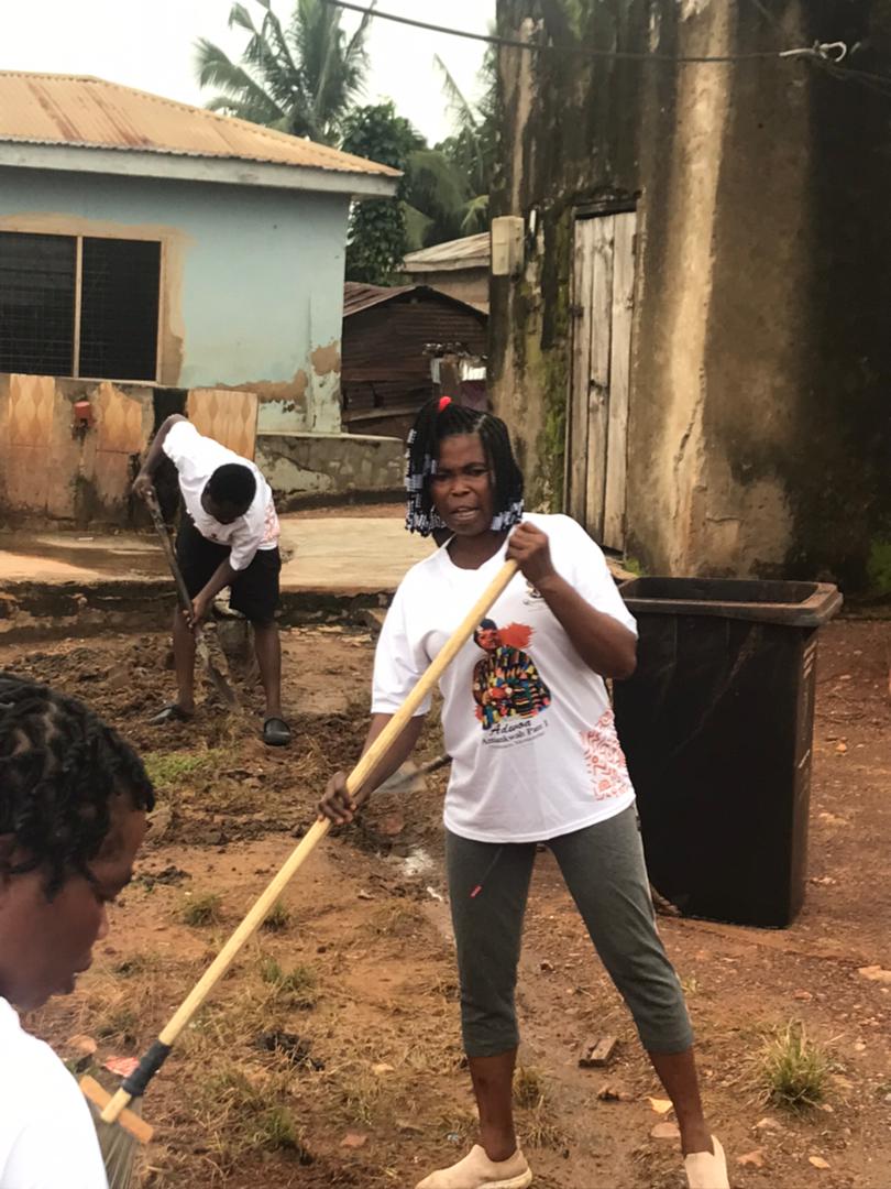 Volunteers sweeping refuse into a bin during the 3rd Anniversary Cleanup